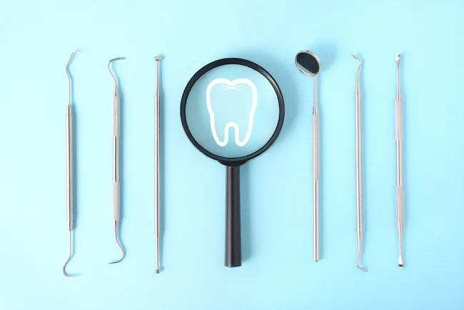虫眼鏡と歯と歯科医師の道具