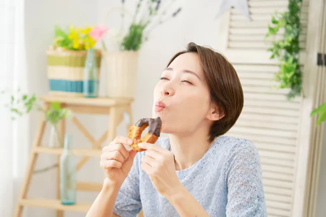 ドーナツをおいしそうに頬張る女性