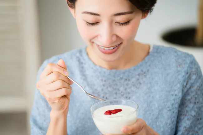 ヨーグルトを食べる女性