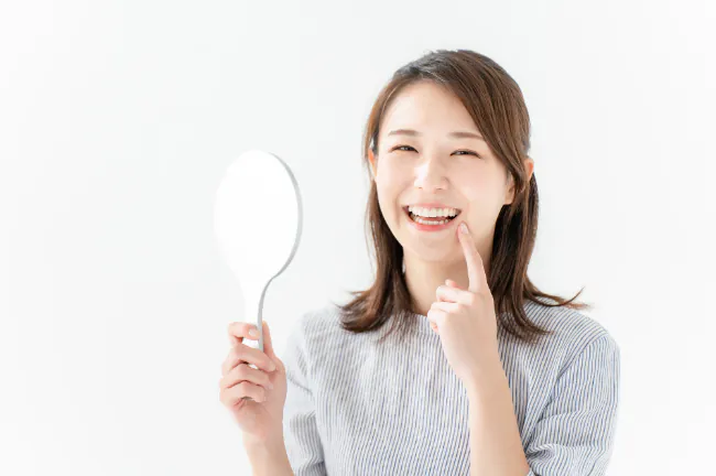 毎日もケアで前歯の虫歯を予防する笑顔の女性