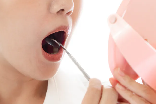 前歯の裏をセルフチェックする様子