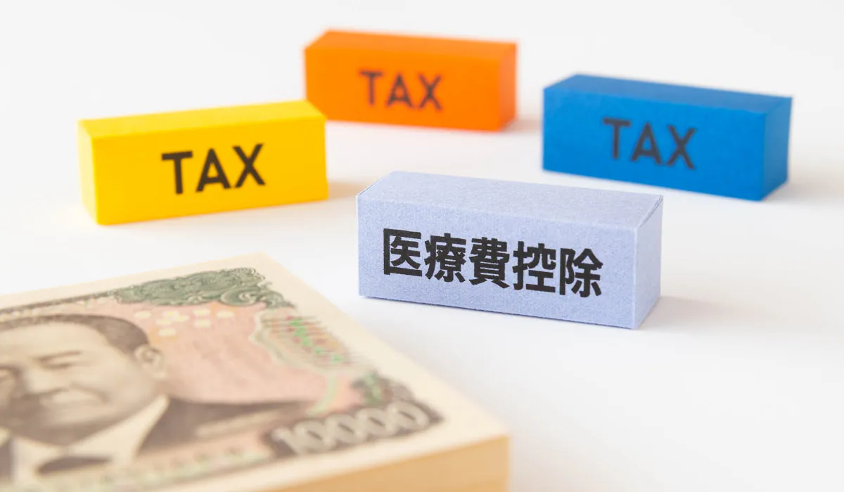 医療費控除とTAXと書かれたブロックと一万円の札束
