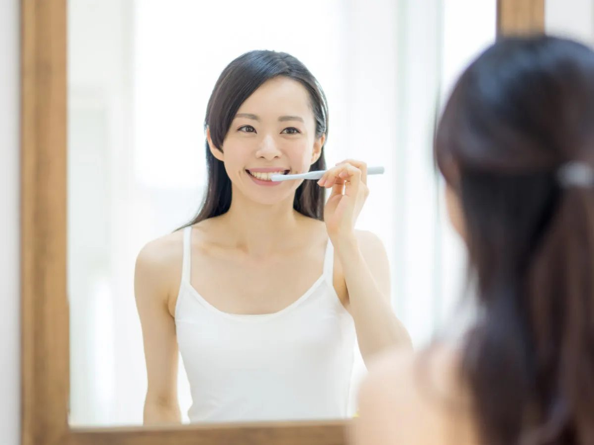 きれいな歯を維持するためのセルフケアとして歯磨きをする女性